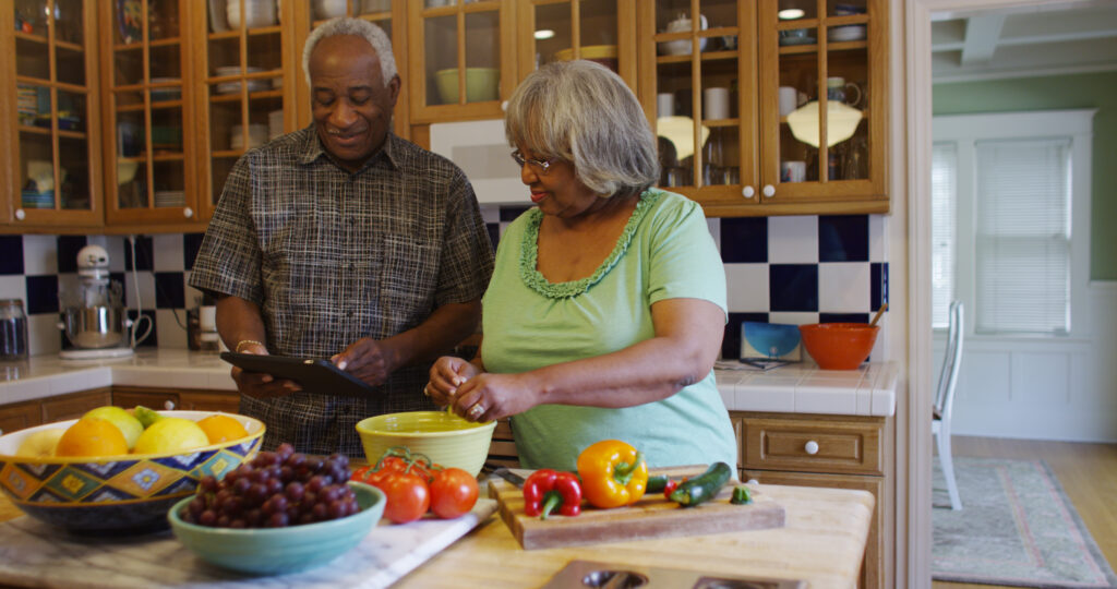 An elderly couple making dinner